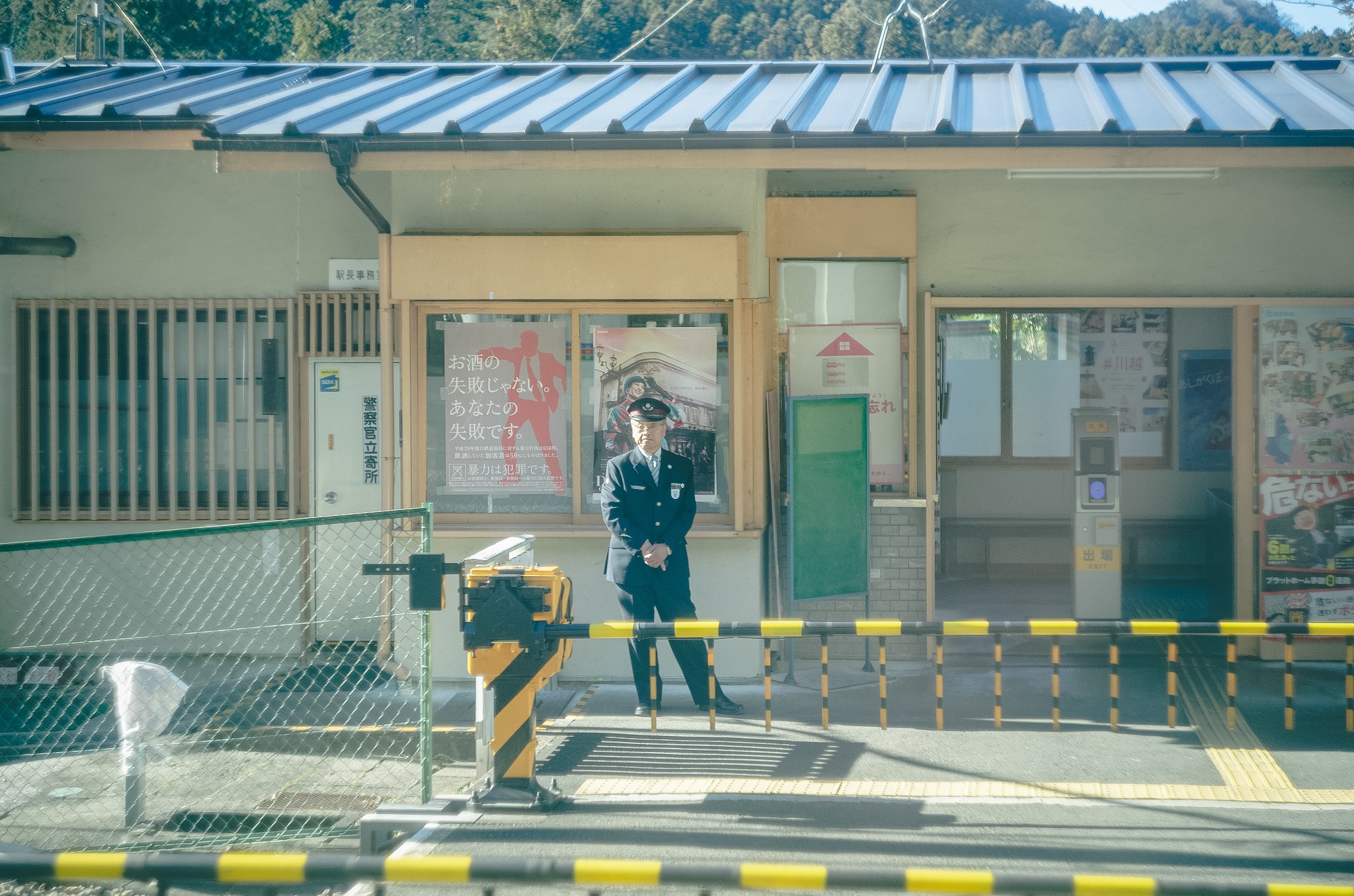 光の中の小さな駅とホームに立つ人