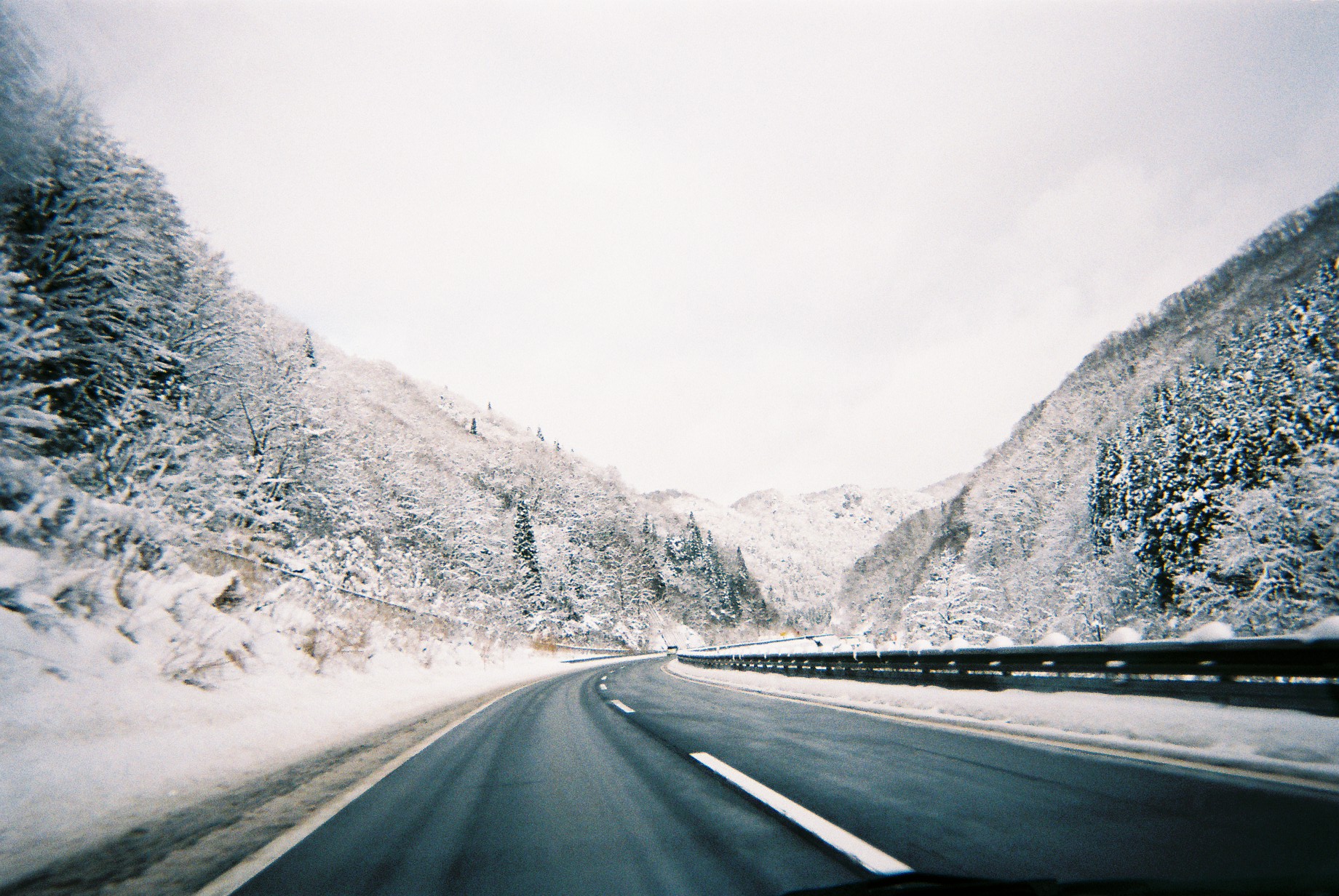 雪に覆われた山間を伸びる道路