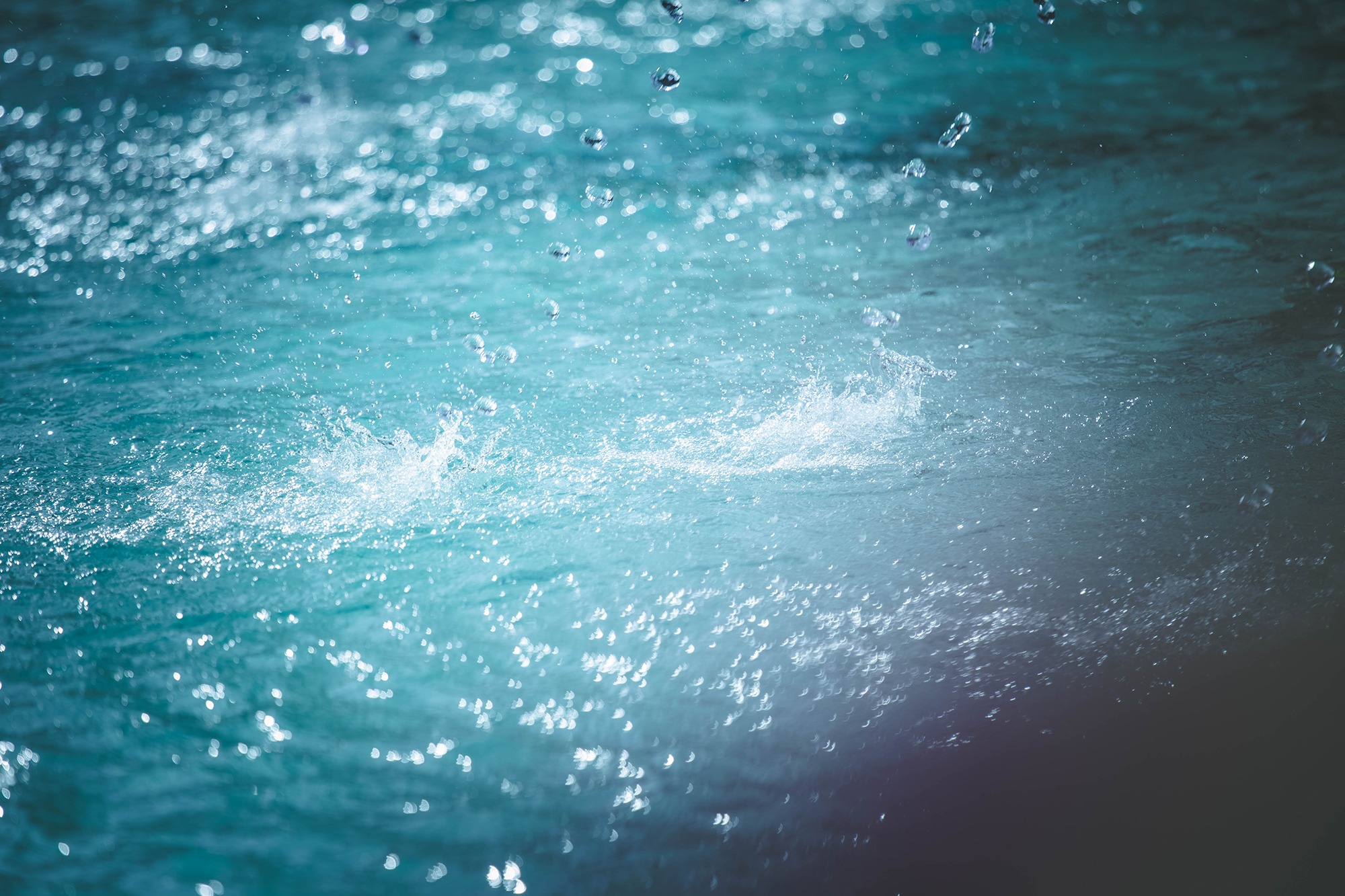 青い水面に弾ける光と水滴
