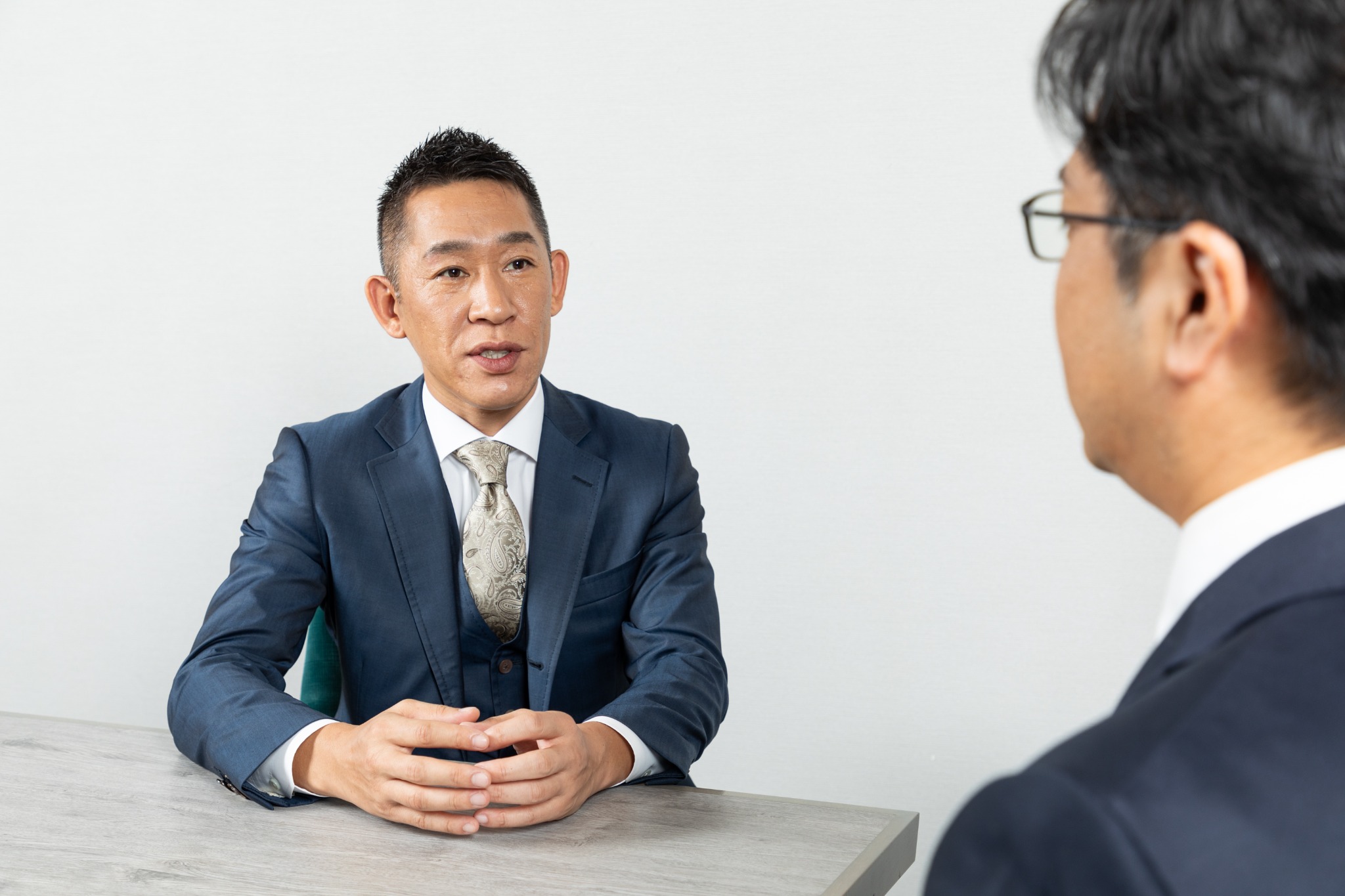 向かい合って話す二人のビジネスパーソン