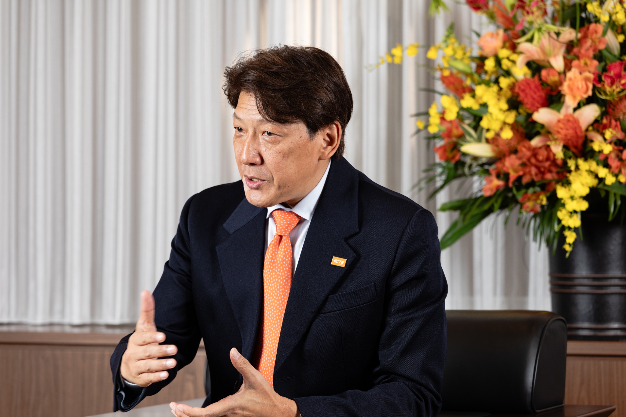 身振りを交えて話す企業経営者