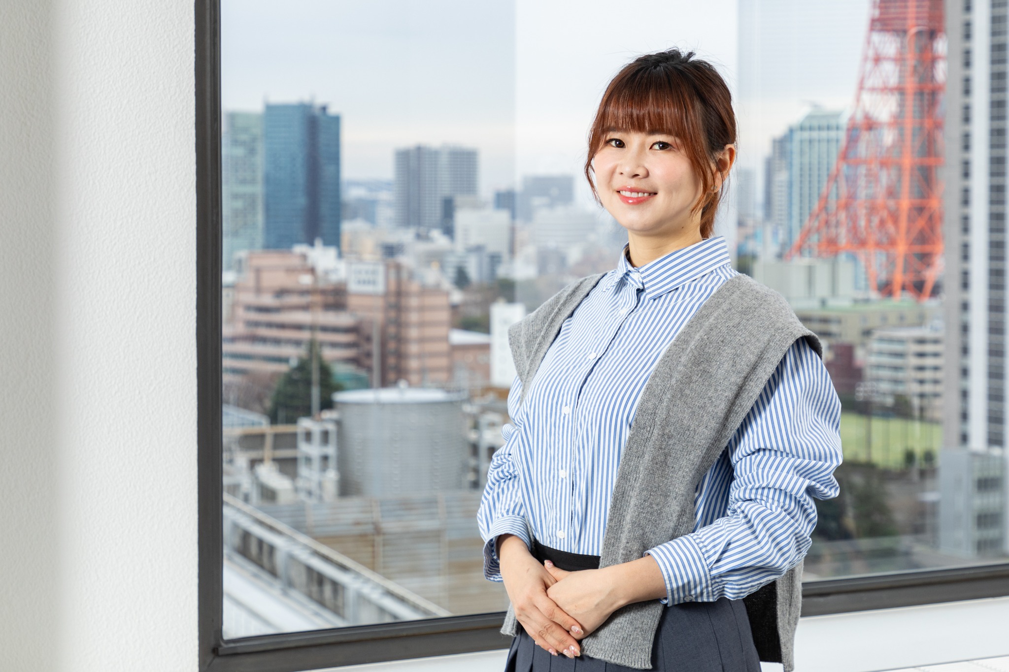 都市を望む窓辺で撮影した社員ポートレート