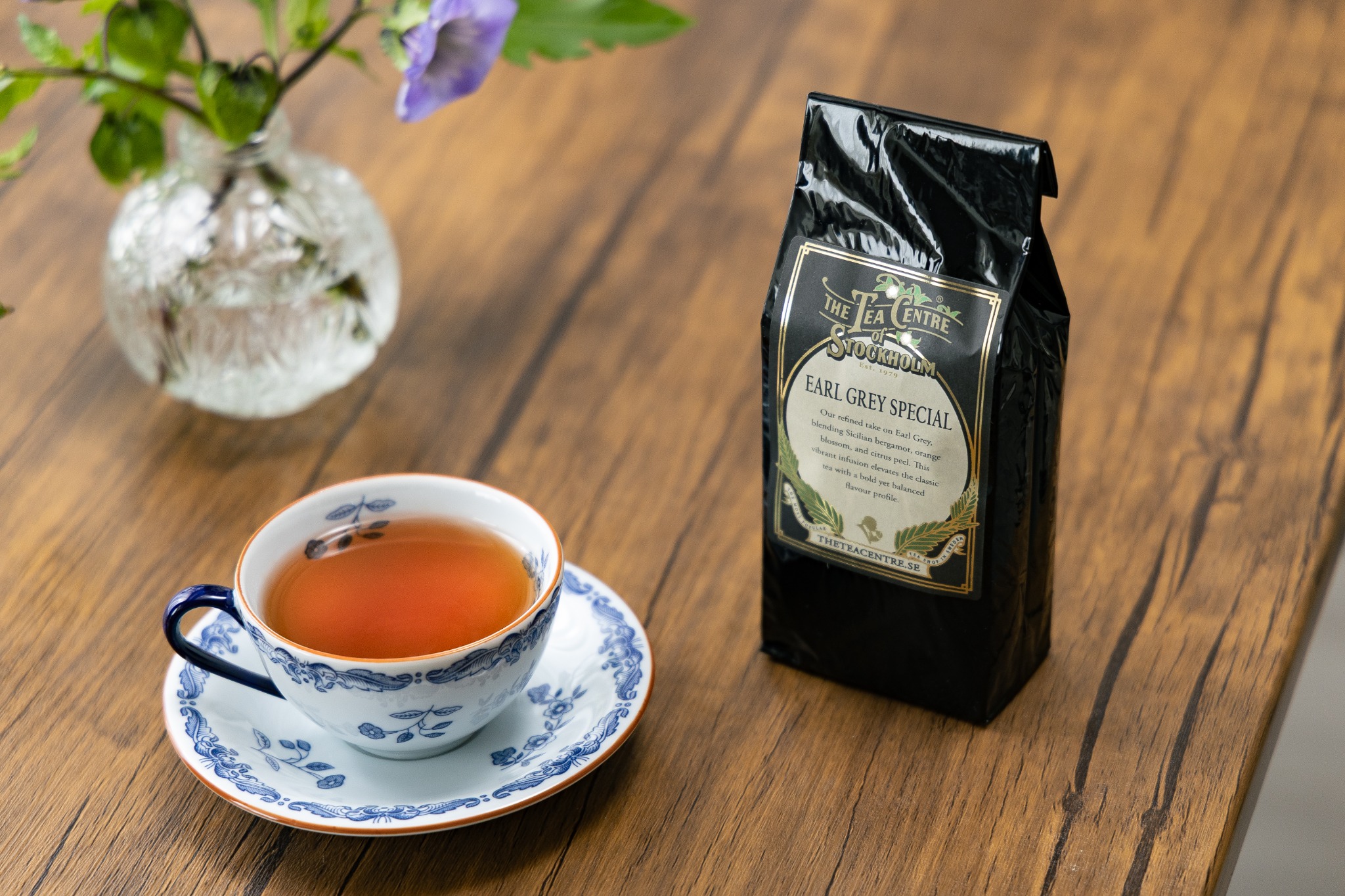 木のテーブルに置かれた紅茶パッケージとティーカップ